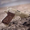 The Walther PPK miniature slide pistol is a full metal gun detailed wood grips.