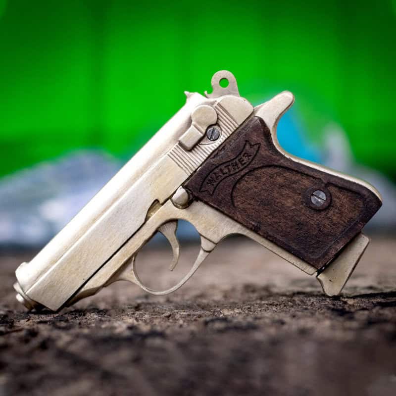 The Walther PPK miniature slide pistol is a full metal gun detailed wood grips.