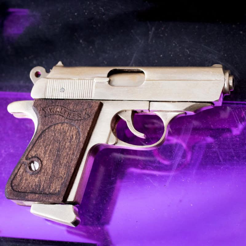 The Walther PPK miniature slide pistol is a full metal gun detailed wood grips.