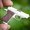 The Walther PPK miniature slide pistol is a full metal gun detailed wood grips.